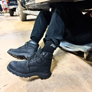 A pair of black bamboo work socks worn with black work boots, visible in an indoor setting.
